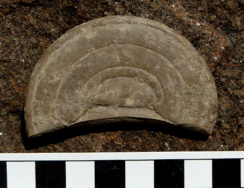 Sculpted limestone or stoneware disc, 65 by 5-6 mm, from trench C at Stensö Castle. What was it for?